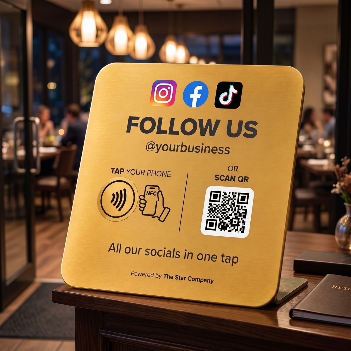 22K gold Social Media Follow Plate on a restaurant host stand, tap or scan to follow