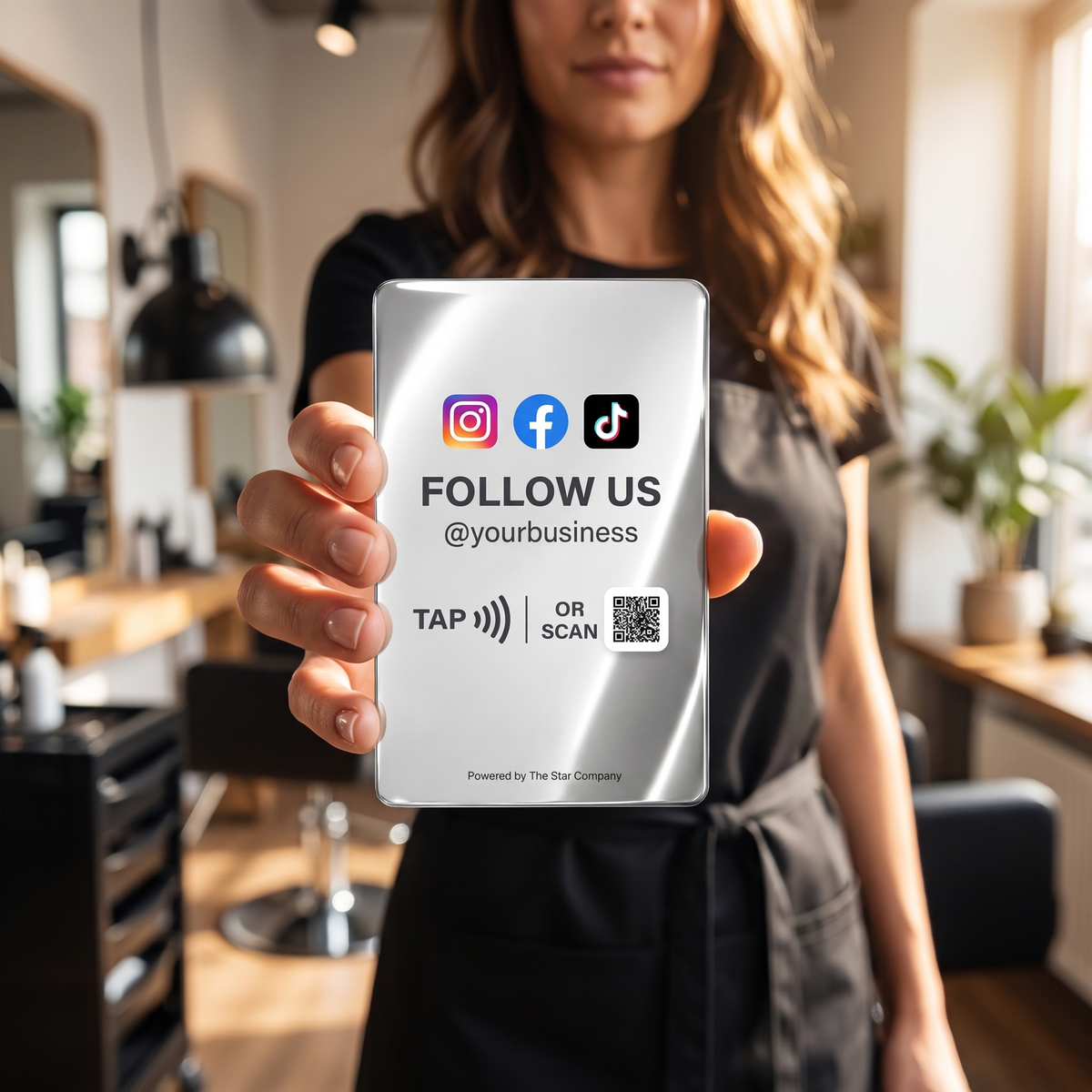 Hair stylist holding the stainless steel Social Media Follow Card in a salon